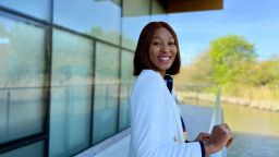 Esther Airemionkhale on a balcony smiling at the camera